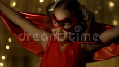 小女孩扮演超级英雄。 搞笑宝宝穿红雨衣打权力超级英雄.. 超级英雄和权力概念